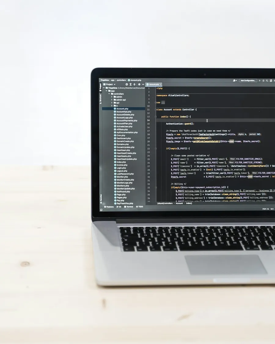 MacBook showing code on a white table